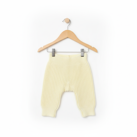 Knitted baby pants on beige hanger